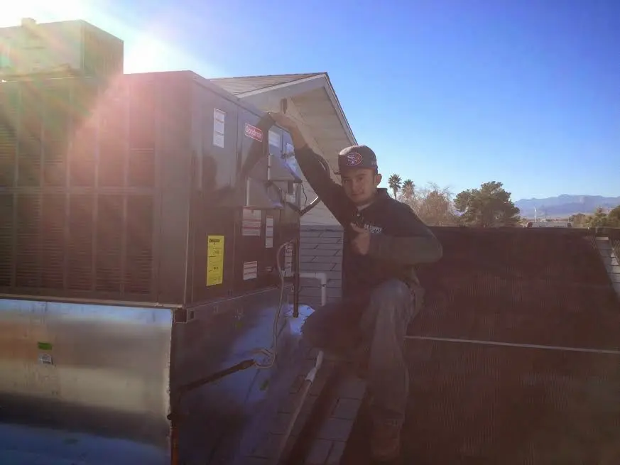 HVAC technician performing AC Tune-Up on a rooftop unit in PiÃ±on Hills